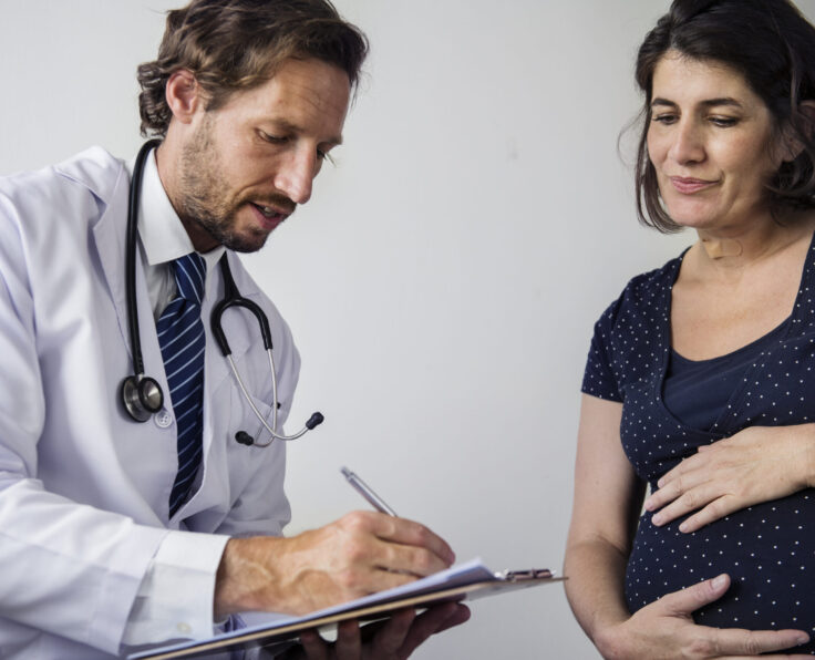 Pregnant woman having fetal monitoring by doctor